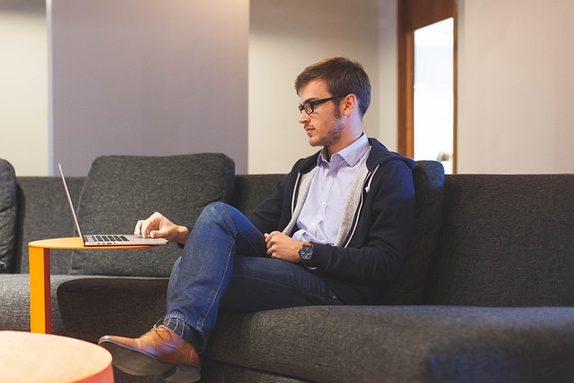 Man in a business casual outfit: navy chinos, light blue oxford shirt, charcoal sport coat, and brown loafers.